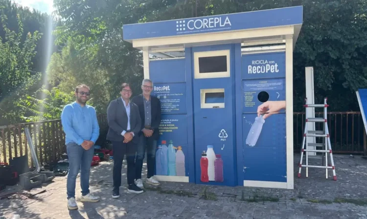 Tre rappresentanti posano accanto a un ecocompattatore RecoPet di COREPLA destinato alla raccolta delle bottiglie in PET, installato nell'ambito del nuovo progetto avviato dal Comune di Ragusa