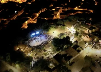 Veduta aerea serale di una precedente edizione del MeMuFest a Giarratana con il pubblico riunito nell'area degli spettacoli.