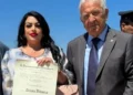 Tiziana Vitanza mostra il diploma di Cavaliere dell'Ordine al Merito della Repubblica Italiana accanto a Corrado Di Stefano durante la cerimonia.