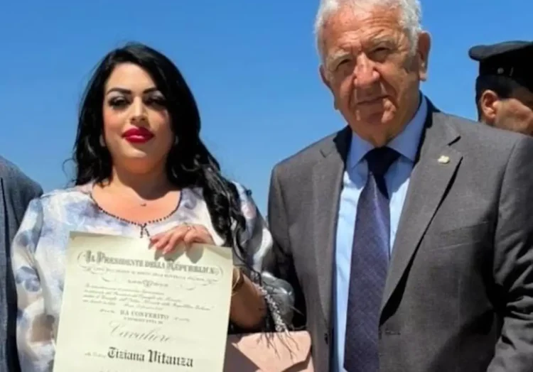 Tiziana Vitanza mostra il diploma di Cavaliere dell'Ordine al Merito della Repubblica Italiana accanto a Corrado Di Stefano durante la cerimonia.