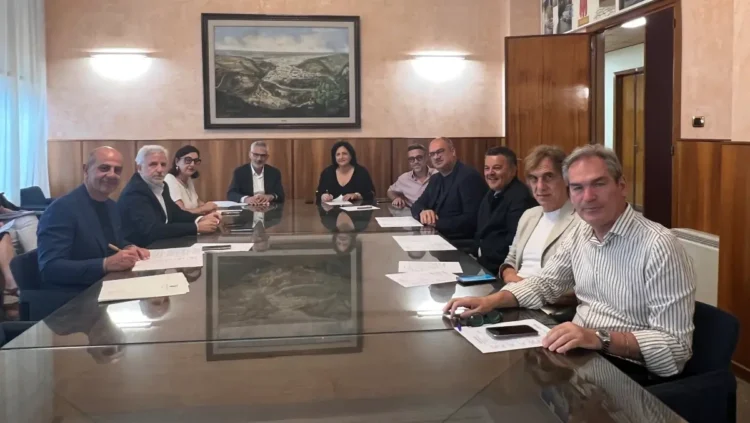 Tavolo riunione con undici persone sedute durante la firma dei protocolli tra il Libero Consorzio e i Comuni della provincia di Ragusa