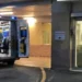 Ambulanza parcheggiata all'ingresso del pronto soccorso di un ospedale con le porte posteriori aperte e l'area di accettazione illuminata.