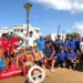 Bagnini, carabinieri e volontari della protezione civile in posa sulla spiaggia accanto a un pattino di salvataggio