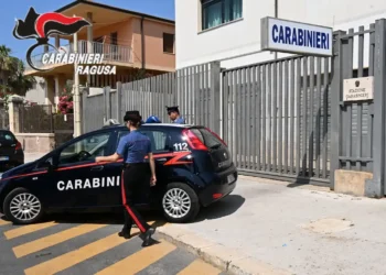 Auto dei Carabinieri parcheggiata davanti al cancello della Stazione Carabinieri di Pozzallo, con due militari in divisa