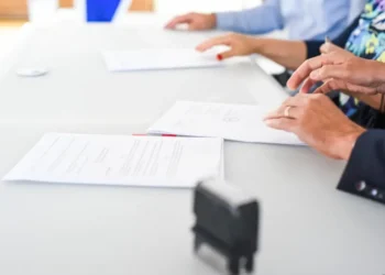 Persone impegnate nella firma di documenti durante un'assunzione, immagine rappresentativa degli incentivi per le assunzioni a tempo indeterminato previsti nel 2026.