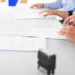 Persone impegnate nella firma di documenti durante un'assunzione, immagine rappresentativa degli incentivi per le assunzioni a tempo indeterminato previsti nel 2026.
