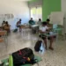 Studenti impegnati nello studio all'interno dell'aula studio estiva di Marina di Ragusa, con postazioni individuali e computer portatili.