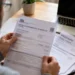 Automobilista consulta una cartella del bollo auto con documenti fiscali su una scrivania.