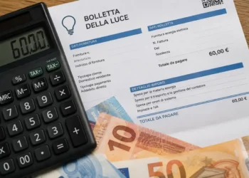 Calcolatrice, bolletta della luce e banconote in euro su un tavolo, immagine rappresentativa del bonus bollette 2026 fino a 60 euro