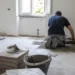 Operaio posa nuove piastrelle durante la ristrutturazione di un'abitazione.