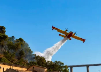 Canadair effettua un lancio d'acqua sulle fiamme dell'incendio che interessa la collina di Monserrato a Modica.