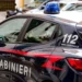 Auto di servizio dei Carabinieri parcheggiata in strada con lampeggianti blu, durante un intervento delle forze dell'ordine.