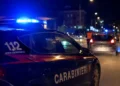 Auto dei Carabinieri con lampeggianti accesi durante un controllo stradale notturno in una strada urbana