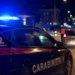 Auto dei Carabinieri con lampeggianti accesi durante un controllo stradale notturno in una strada urbana