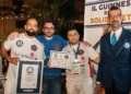 Carmelo Celeste, pizzaiolo originario di Comiso, posa con il certificato del Guinness World Record insieme ad altri partecipanti e a un giudice ufficiale durante la cerimonia di premiazione a Napoli