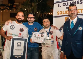 Carmelo Celeste, pizzaiolo originario di Comiso, posa con il certificato del Guinness World Record insieme ad altri partecipanti e a un giudice ufficiale durante la cerimonia di premiazione a Napoli