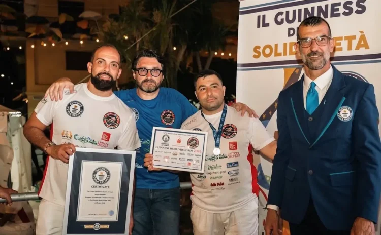 Carmelo Celeste, pizzaiolo originario di Comiso, posa con il certificato del Guinness World Record insieme ad altri partecipanti e a un giudice ufficiale durante la cerimonia di premiazione a Napoli