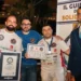 Carmelo Celeste, pizzaiolo originario di Comiso, posa con il certificato del Guinness World Record insieme ad altri partecipanti e a un giudice ufficiale durante la cerimonia di premiazione a Napoli