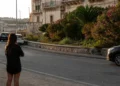 La circonvallazione di Ragusa Ibla con il muretto in pietra, oleandri in fiore e il palazzo barocco sullo sfondo