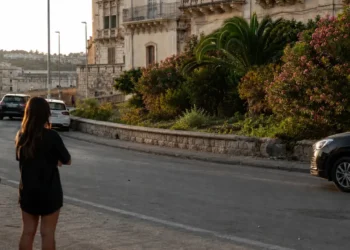 La circonvallazione di Ragusa Ibla con il muretto in pietra, oleandri in fiore e il palazzo barocco sullo sfondo