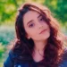 Claudia Presti, giovane donna di 26 anni, capelli castani, in un giardino fiorito