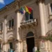 Facciata del Palazzo Comunale di Scicli con le bandiere italiana, europea e siciliana esposte sul balcone principale