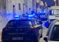 Auto della Guardia di Finanza con lampeggianti blu accesi in un vicolo notturno durante un servizio di controllo del territorio