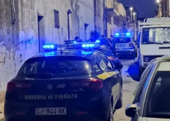 Auto della Guardia di Finanza con lampeggianti blu accesi in un vicolo notturno durante un servizio di controllo del territorio