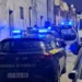 Auto della Guardia di Finanza con lampeggianti blu accesi in un vicolo notturno durante un servizio di controllo del territorio