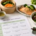 Piatto con salmone, riso, verdure al vapore e insalata accanto a un menù della dieta cinese, simbolo di un'alimentazione equilibrata ispirata alla tradizione orientale