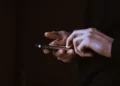 Persona utilizza uno smartphone, simbolo della gestione digitale di pagamenti e notifiche prima delle vacanze
