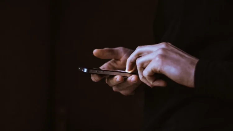 Persona utilizza uno smartphone, simbolo della gestione digitale di pagamenti e notifiche prima delle vacanze