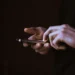 Persona utilizza uno smartphone, simbolo della gestione digitale di pagamenti e notifiche prima delle vacanze