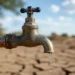 Primo piano di un rubinetto esterno da cui cade una sola goccia d'acqua, con il terreno arido e screpolato sullo sfondo, a rappresentare l'emergenza idrica
