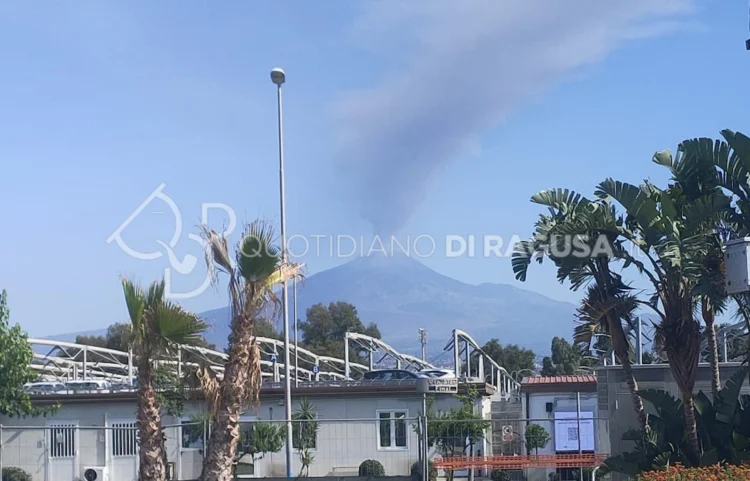L'Etna in attività con una colonna di cenere che si alza dal cratere, osservata dall'area dell'aeroporto di Catania