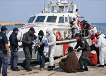 Sbarco di migranti a Pozzallo con operatori di polizia e motovedetta