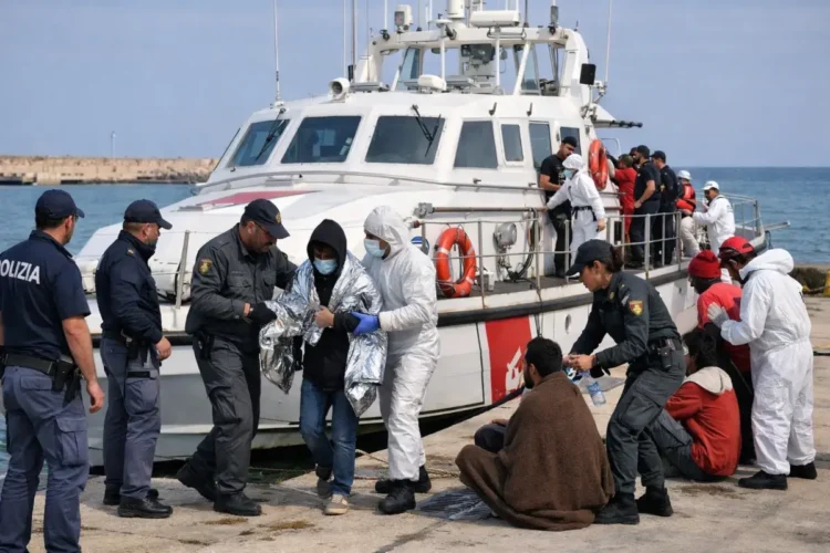 Sbarco di migranti a Pozzallo con operatori di polizia e motovedetta