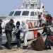 Sbarco di migranti a Pozzallo con operatori di polizia e motovedetta