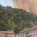 Vasto incendio sulla collina di Monserrato a Modica, con alte fiamme e una densa colonna di fumo sopra la pineta, osservata dalle abitazioni sottostanti