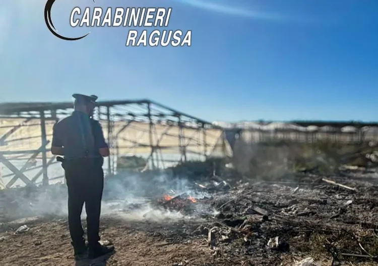 Un Carabiniere osserva un piccolo rogo di rifiuti plastici e vegetali in un'area agricola ad Acate durante un'operazione di contrasto alla combustione illecita dei rifiuti