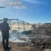 Un Carabiniere osserva un piccolo rogo di rifiuti plastici e vegetali in un'area agricola ad Acate durante un'operazione di contrasto alla combustione illecita dei rifiuti