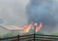 Incendio a Monserrato, a Modica, con alte fiamme e una densa nube di fumo nero a pochi metri dalle abitazioni della zona.