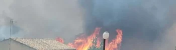 Incendio a Monserrato, a Modica, con alte fiamme e una densa nube di fumo nero a pochi metri dalle abitazioni della zona.