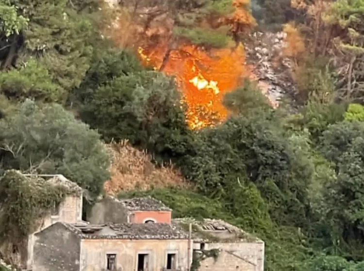 Vasto incendio nell'area di Monserrato a Modica, con alte fiamme che interessano la vegetazione alle spalle di alcune abitazioni.