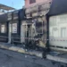 Negozio di abbigliamento danneggiato da un incendio a Vittoria, con la facciata annerita dalle fiamme e l'area transennata dopo l'intervento dei vigili del fuoco