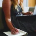 Giovane lavoratrice utilizza un computer portatile mentre prende appunti, immagine di repertorio sul bonus giovani 2026 per la stabilizzazione dei contratti di lavoro
