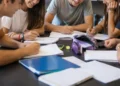 Un gruppo di adolescenti studia e lavora insieme attorno a un tavolo in uno spazio educativo, immagine rappresentativa del progetto finanziato dal Distretto Socio-Sanitario 44 per i giovani.