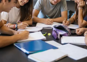 Un gruppo di adolescenti studia e lavora insieme attorno a un tavolo in uno spazio educativo, immagine rappresentativa del progetto finanziato dal Distretto Socio-Sanitario 44 per i giovani.