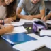 Un gruppo di adolescenti studia e lavora insieme attorno a un tavolo in uno spazio educativo, immagine rappresentativa del progetto finanziato dal Distretto Socio-Sanitario 44 per i giovani.
