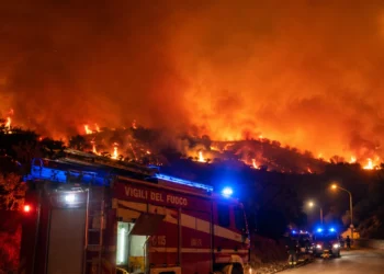 Mezzo dei Vigili del Fuoco impegnato durante un vasto incendio nei pressi di Santo Stefano Quisquina, con le fiamme che avanzano sulla collina illuminate nella notte
